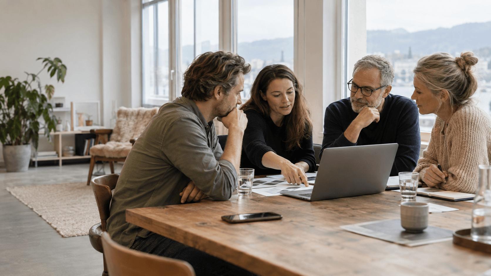 Vier fiktive Personen besprechen an einem Tisch gemeinsame Ideen. KI-generierte Beispielszene, keine reale Teamreferenz.